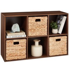 a shelf with baskets and books on it next to a vase, bookends and other items