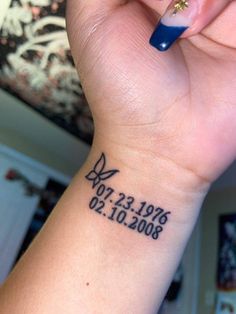 a woman's wrist with a tattoo on it that reads date and butterfly in black ink