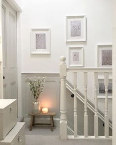 a white staircase with pictures on the wall