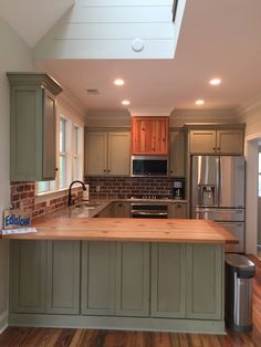 a kitchen with wooden floors and green cabinets