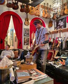 a man playing an electric guitar in a room full of guitars