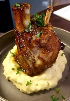 a piece of meat on top of mashed potatoes