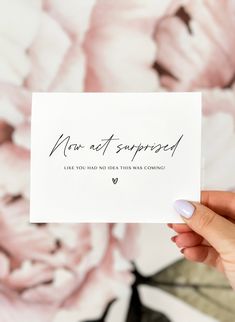 someone holding up a card with the words sorry on it in front of a floral background