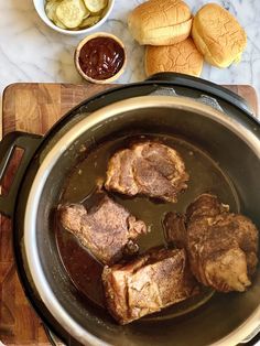 the meat is being cooked in the pot on the stove top next to other foods