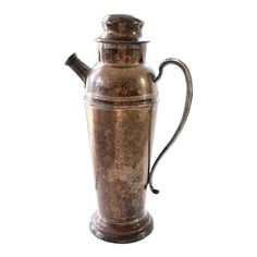 an old metal pitcher is shown against a white background with the lid down and it's handle still attached