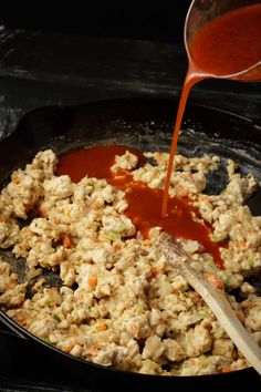 the food is being poured into the skillet