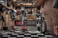 two motorcycles are parked in a garage with checkered flooring