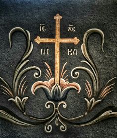 the cross is on top of a black carpet with floral designs and scrolls around it