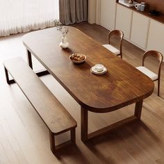 a wooden table with two chairs and a bowl of food on it next to a window