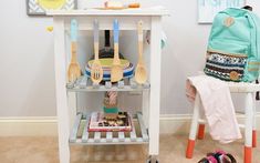 a kitchen cart with utensils on it next to a chair