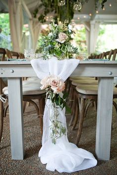 the table is set with flowers and greenery