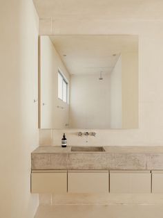 a bathroom with a sink, mirror and counter top in white color space between two walls