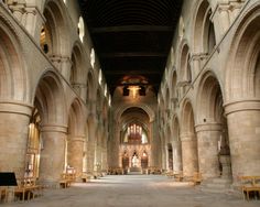 the inside of an old church with stone arches and pews on either side of the navel