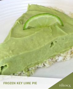 there is a piece of cake with green frosting on it and a lime slice