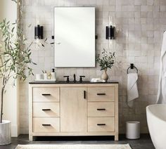 a bathroom with a sink, mirror and bathtub next to a rug on the floor