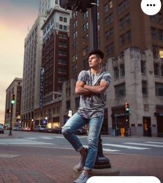 a man sitting on top of a pole in the middle of a street