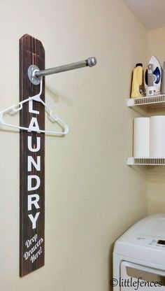 a laundry sign hanging on the wall next to a washer and dryer