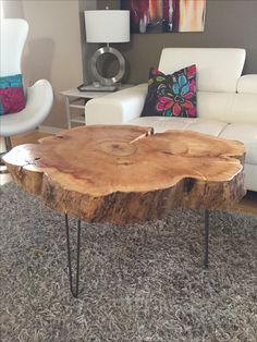 a wooden table sitting on top of a rug in a living room next to a white couch