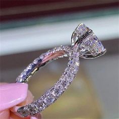 a close up of a person holding a diamond ring with the price tag below it