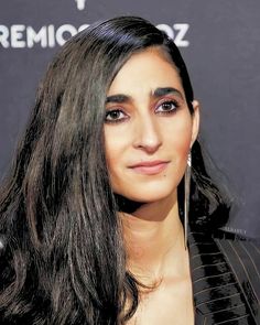 an image of a woman with long black hair smiling at the camera and looking straight ahead