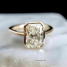 a yellow diamond ring sitting on top of a marble slab