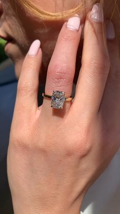 a close up of a person wearing a ring with a diamond on it's finger