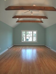 an empty room with hard wood floors and sky blue paint on the walls is shown