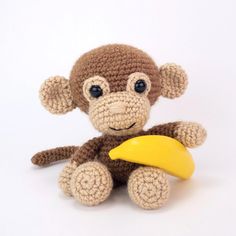 a crocheted monkey with a banana toy in front of it's face