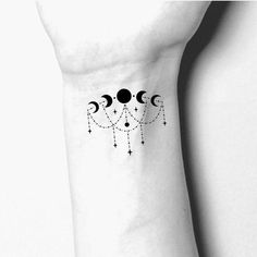 a woman's wrist tattoo with three phases and stars on the back of her arm