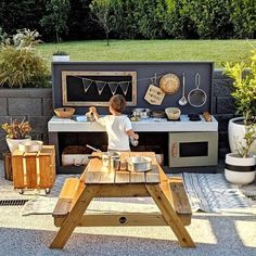 a little boy standing in front of an outdoor kitchen