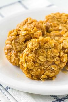 three oatmeal cookies on a white plate