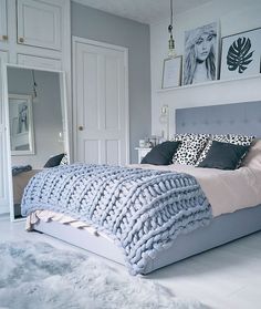 a bedroom with a bed, rugs and pictures on the wall above it's headboard