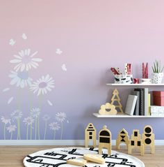 a child's room with pink walls and white flowers on the wall, along with toys