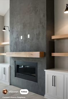 an empty living room with a fireplace and built - in shelving