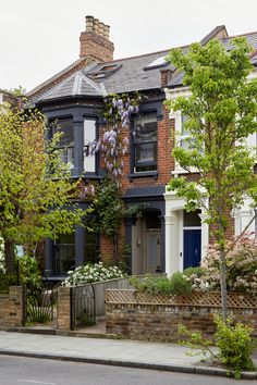 a row of houses with trees and bushes on the sidewalk