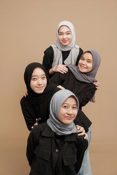 three women in hijabs are posing for the camera with their arms around each other