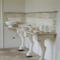 two white sinks sitting next to each other on top of a tiled floor in a bathroom