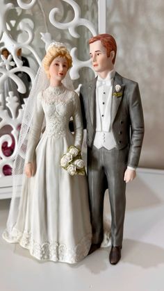 a bride and groom figurine standing next to each other