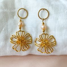 Pretty dangling earrings to celebrate spring. They are composed of circled stud earrings with a diamond effect, in stainless steel, a cultured pearl and openwork flowers gilded with 24K fine gold. Spring Pearl Drop Gold Jewelry, Spring Gold Jewelry With Pearl Drop, Gold Feminine Dangle Flower Earrings, Gold Metal Earrings With Flower Charm, Spring Pearl Drop Gold Earrings, Spring Gold Pearl Drop Earrings, Gold Pearl Drop Earrings For Spring, Gold Flower Earrings Spring Gift, Gold Flower-shaped Pearl Earrings As Gift