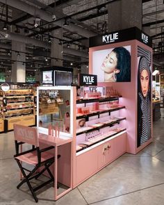 the inside of a cosmetics store with pink counter tops and display cases for makeup products