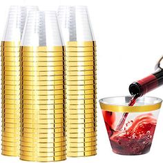 gold cups with red liquid being poured into one cup and another glass filled with wine