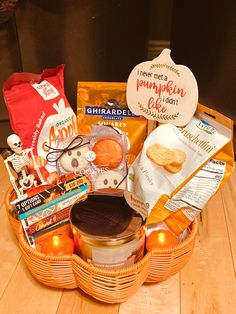 a basket filled with lots of food on top of a wooden table next to an orange bag