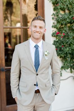 a man wearing a suit and tie standing in front of a door