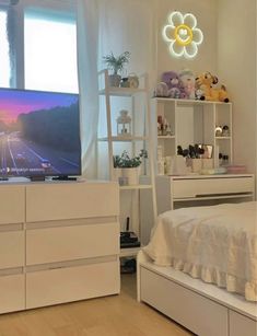 a bedroom with white furniture and a flat screen tv