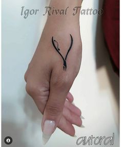 a woman's hand with a small tattoo on her left thumb and the word igor rival tattoo written in black ink