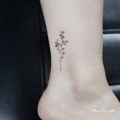 a small flower tattoo on the ankle