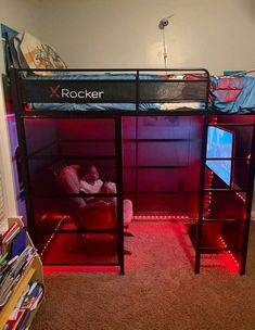 there is a bunk bed with a red light under it and a person sleeping on the bottom