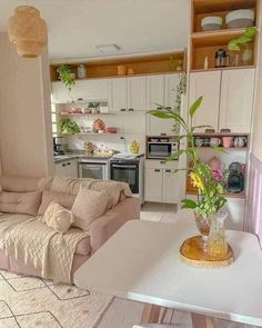 a living room filled with furniture next to a kitchen and dining table in front of a stove top oven