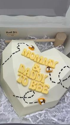 there is a cake in the shape of a heart with bees on it that says mommy and daddy to be