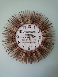 a clock that is made out of wood sticks and has writing on the front side